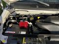 Close-up of the engine compartment of a 2014 Ford Econoline showing the battery and various engine components