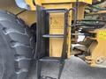 A yellow ladder attached to a large machinery piece with a close-up view of the ladder rungs and a diagram mounted on the side of the machine