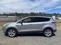 A 2015 Ford Escape in silver color parked with its side profile visible