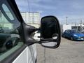 A side view of a 2008 Ford Econoline featuring a large rearview mirror and part of the van's body