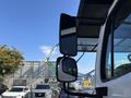 2019 Freightliner M2 106 truck with dual side mirrors reflecting a clear sky and nearby construction equipment