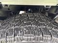 Close-up of a large rugged tire showing deep treads and textured rubber surface designed for off-road performance on a 2020 Ford F-150