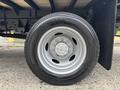 Close-up of a 2023 Ford F-450 Super Duty tire showcasing a silver wheel with multiple lug nuts and a black tire with tread patterns