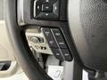 Close-up of the steering wheel controls of a 2018 Ford F-150 featuring buttons for cruise control settings including set, resume, cancel, and on/off