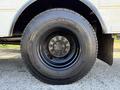 Close-up of a black tire mounted on a silver wheel with multiple bolts on a 2013 International CE300