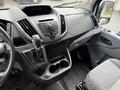 Interior view of a 2017 Ford Transit showcasing the dashboard controls gear shift and cup holders