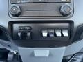 The dashboard control panel of a 2012 Ford F-350 SD featuring various button switches and knobs for auxiliary functions and climate control