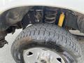 Close-up of a 2014 Ford F-250 SD wheel showcasing a rugged tire and suspension system with a visible yellow shock absorber