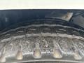 Close-up of a tire tread on a 2013 Freightliner 114SD showing deep grooves and rubber texture