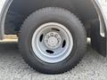 A close-up of a metallic wheel from a 2018 Ford Econoline with a rugged tire showing a patterned tread and five-lug nut design