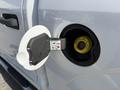 A 2018 Ford F-150 fuel cap is open revealing the fuel tank with an informational sticker on the cap
