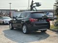 A black 2013 BMW X3 with a sleek design featuring a prominent grille and modern headlights viewed from the rear at an angle