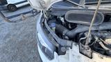 A 2021 Ford Transit with its hood raised showing the engine compartment and various components inside
