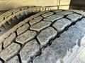 Close-up of the tread pattern on a heavy-duty tire from a 2012 Freightliner M2 106 showing deep grooves and rugged design for traction and durability