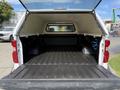 The image shows the open bed of a 2019 Chevrolet Silverado 1500 with a cap roof and a lined black interior