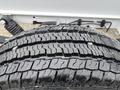 A close-up view of a tire showcasing its tread pattern on a 2023 RAM Promaster 3500 with a small object embedded in the rubber