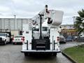 A 2005 Freightliner M2 106 bucket truck with an extended lift and a white utility bucket attached to the upper boom