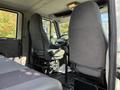 Interior view of a 2012 International 4300 showing two upholstered driver's seats and the steering wheel in the foreground