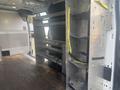 Interior of a 2017 Ford Transit van featuring metal shelving units and straps for securing cargo