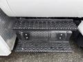 Close-up of the step plates on a 2011 Ford F-650 featuring a perforated design with water droplets on the surface