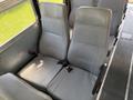 Two gray upholstered seats with vertical lines and seat belts inside a bus model 2009 International 3000 CE