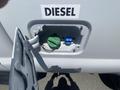 A 2016 Ford F-350 SD with an open fuel door revealing the diesel fuel cap and nozzle attachment