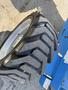 Close-up of a large, rugged tire from a 2012 Genie Z 45/25 aerial lift showing deep treads and a metallic rim