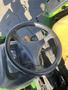 A black steering wheel of a 2008 John Deere 3320 tractor with controls and gauges visible in the foreground