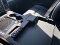 Interior view of a 2018 RAM 3500 center console featuring cup holders and control buttons in a black finish