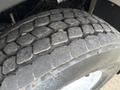 A close-up view of a rugged tire from a 2012 International 7400 showing worn tread patterns and dirt on the surface
