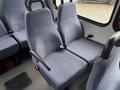 Two blue fabric seats with armrests inside a 2018 Chevrolet Express van arranged in a row with seat belts attached.
