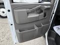Interior door panel of a 2021 Chevrolet Express featuring a handle a latch and storage compartments