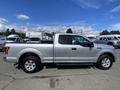 A silver 2015 Ford F-150 truck with a crew cab and a short bed is shown from the side angle