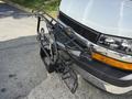 A 2020 Chevrolet Express van with a black metal bike rack attached to the front bumper