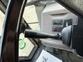 Close-up of the steering wheel and control panel of a 2005 Case 570 featuring a gear shift lever and various buttons