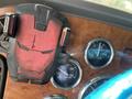 A red and black Iron Man-themed phone holder attached to the dashboard of a 2009 Peterbilt truck with various gauges visible