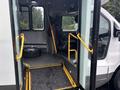 The interior entrance of a 2018 Chevrolet Express featuring a ramp, a driver's seat, and a visible spare tire in the corner