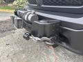 A 2016 RAM 1500 with a mounted winch on the front bumper and a cable safety strap attached to the winch