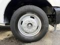 A close-up view of a silver wheel and tire from a 2015 Ford F-350 displaying a five-bolt pattern and textured tread on the tire
