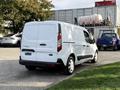 A white 2020 Ford Transit Connect van with a clean design and rear doors open partially is parked on a paved surface