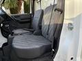 Interior of a 2008 Suzuki Carry featuring two front seats with patterned fabric and a floor console with gear shift and armrest