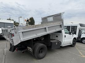 A white 2004 Ford F-350 SD with a raised dump bed positioned at an angle
