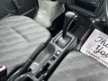 Interior view of a 2010 Suzuki Carry showing the gear shift lever and the driver and passenger seats with fabric upholstery
