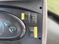 Control panel of a 2005 Case 570 tractor featuring gauges and two switches labeled with yellow stickers