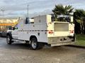 A white 2010 Ford F-550 truck with a utility body featuring storage compartments and equipment mounted on top