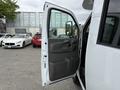 A 2013 Chevrolet Express van with the driver's door open revealing the interior door panel and adjacent side mirror