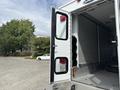 A 1994 GMC Vandura 3500 with an open rear door revealing a spacious interior designed for cargo or equipment storage