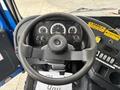 Steering wheel and dashboard of a 2017 Autocar Xpert showing gauges buttons and caution stickers