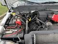 Engine compartment of a 2015 Ford F-350 showing the battery and various engine components including hoses and wires