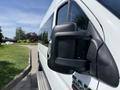A close-up of the side mirror of a 2021 RAM Promaster with a silver body and the RAM logo visible on the side panel